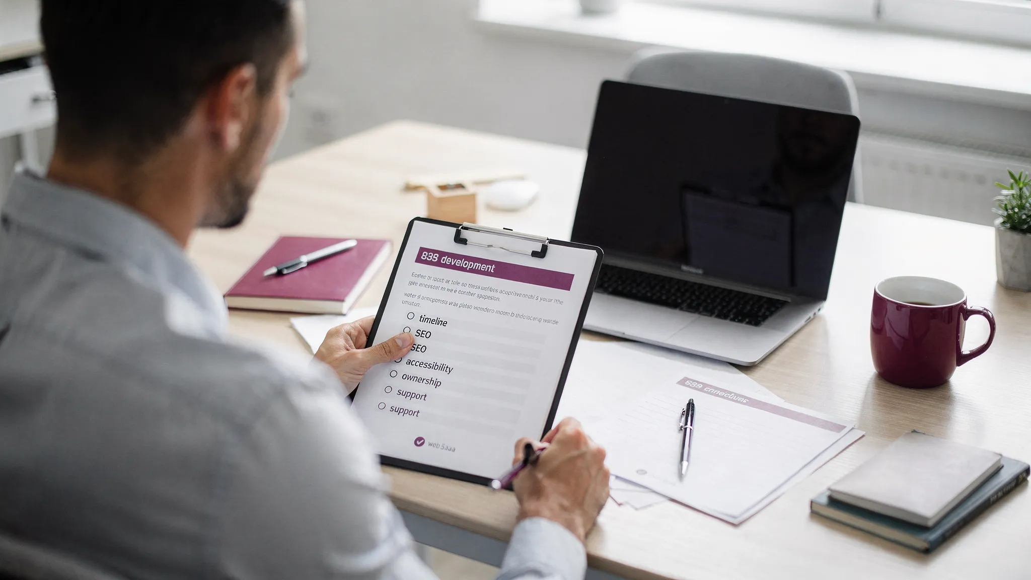 A business owner reviewing a web development proposal at a desk with a checklist labeled scope, timeline, SEO, speed, accessibility, ownership, and support, with a laptop open facing the correct direction and no visible screen content.